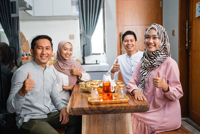 Portrait of smiling friends sitting at home