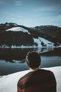 Rear view of person looking at snowcapped mountain against sky