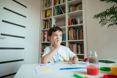 Portrait of boy sitting on table