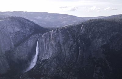 Scenic view of waterfall against sky