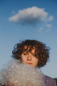 Portrait of woman with plastic against blue sky