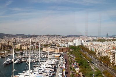 Sailboats moored at harbor against sky