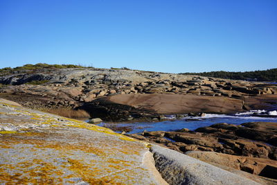 Scenic view of rocks against clear blue sky