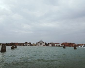 Buildings in city against cloudy sky