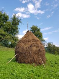 Hay bales on field against sky