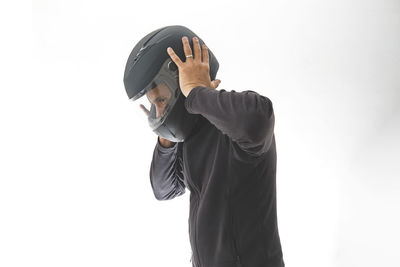 Man with a motorcycle helmet giving a thumbs up gesture. isolated on white studio wall.