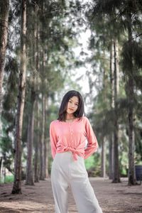 Portrait of woman standing against pink trees