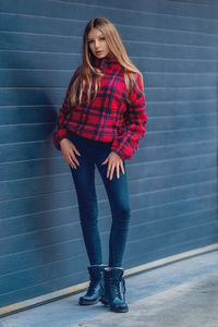 Full length of woman standing against wall