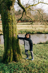 Portrait of man standing on tree trunk