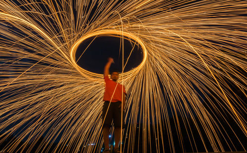 Full length of man with umbrella standing at night