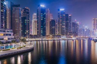 Reflection of illuminated buildings in city at night