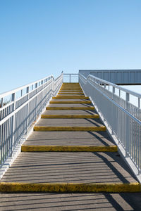 Low angle view of footbridge against clear blue sky