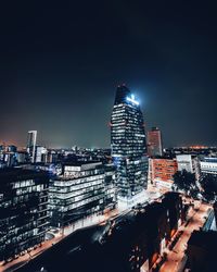 Illuminated buildings in city against sky at night