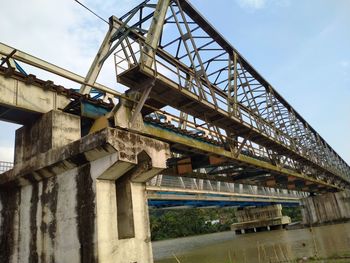 Low angle view of bridge over river against sky