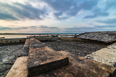 Surface level of wood at beach against sky