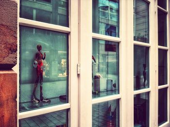 Reflection of man on glass window of building