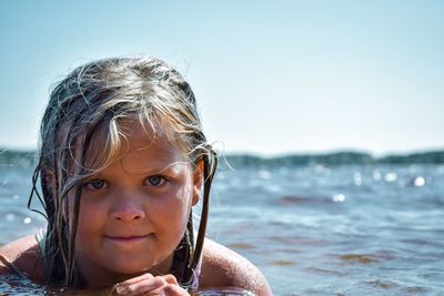 Portrait of cute girl at beach against sky