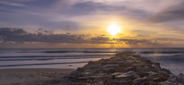 Scenic view of beach against sky during sunset