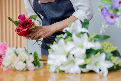 Midsection of woman holding rose bouquet