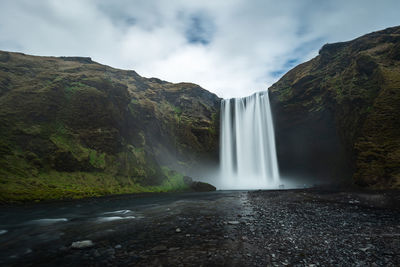 Low angle view of waterfall against sky