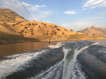 Man wakeboarding in sea against sky