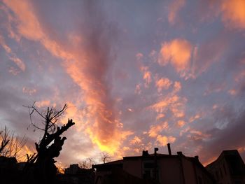 Low angle view of silhouette buildings against dramatic sky