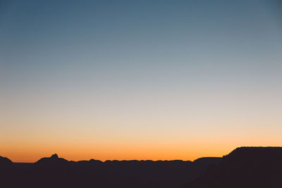 Silhouette landscape against clear sky during sunset