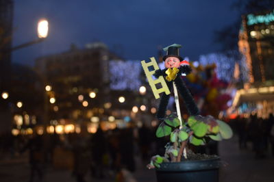 Close-up of illuminated christmas lights in city at night