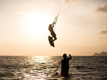 View of silhouette kite surfing in the ocean