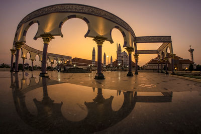 Reflection of central java greatest mosque on wet street during sunset
