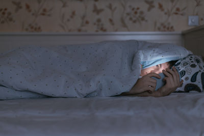 Cute baby boy lying on bed at home