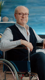 Portrait of senior man sitting on wheelchair at hospital