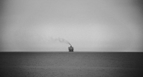 Scenic view of sea against sky and ship on the horizon