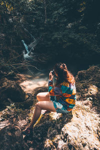 High angle view of woman photographing in forest