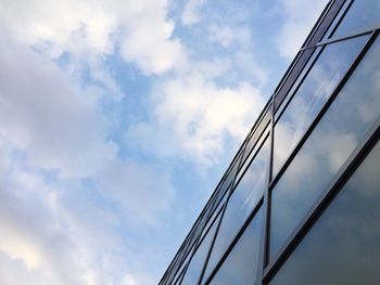 Low angle view of modern building against cloudy sky