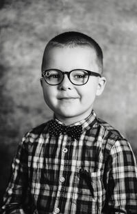 Portrait of boy standing against background 