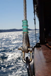 Close-up of rope tied on bollard against sky