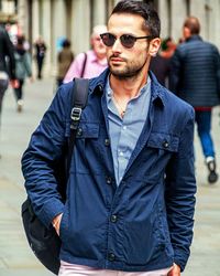 Portrait of young man wearing sunglasses standing in city