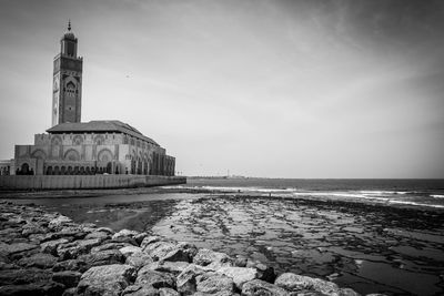 Mosque by beach against sky