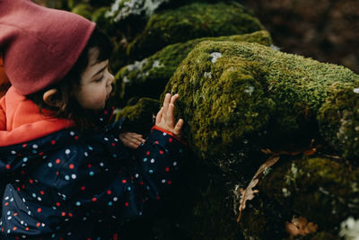 Cute girl touching moss on rock