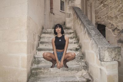 Young woman sitting on staircase