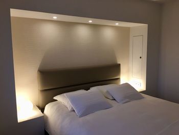 View of illuminated electric lamp on bed at home