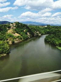 Scenic view of river amidst trees against sky