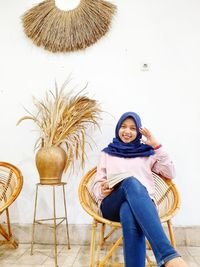 Portrait of smiling young woman sitting on chair