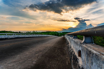 Road by land against sky during sunset