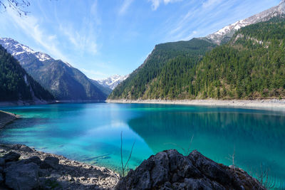 Panoramic view of lake and mountains against blue sky