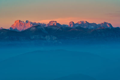 Scenic view of snowcapped mountains against sky during sunset