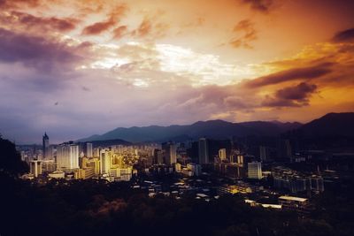 View of cityscape against cloudy sky during sunset