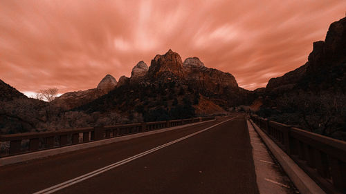 Empty road by mountain against sky