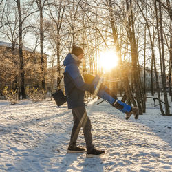 Father carrying son while standing on snowy land in forest